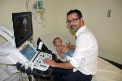 El Dr. Ferran Rosés visitant un infant a la consulta de l'HUV